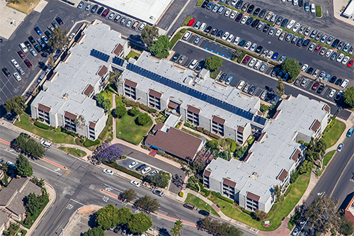 Aerial shot of an apartment complex in Garden Grove with solar panels installed on top
