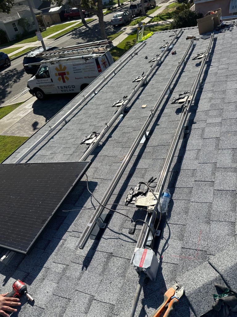 Solar panels being installed on a home's gray shingled roof.