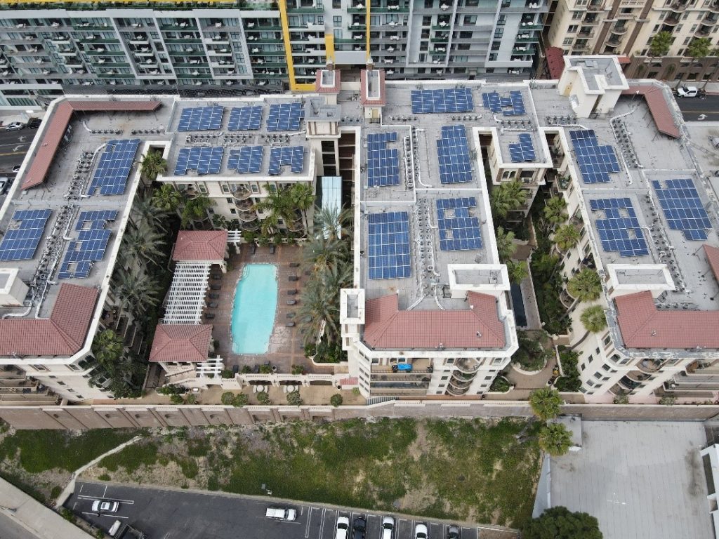 Aerial view of multifamily housing property in Los Angeles, CA; Solar panels shown on the rooftops.