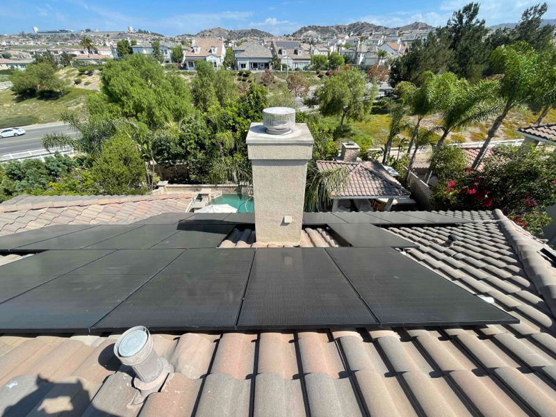 A section of solar panels surrounding a chimney on the roof of a home in Yorba Linda.