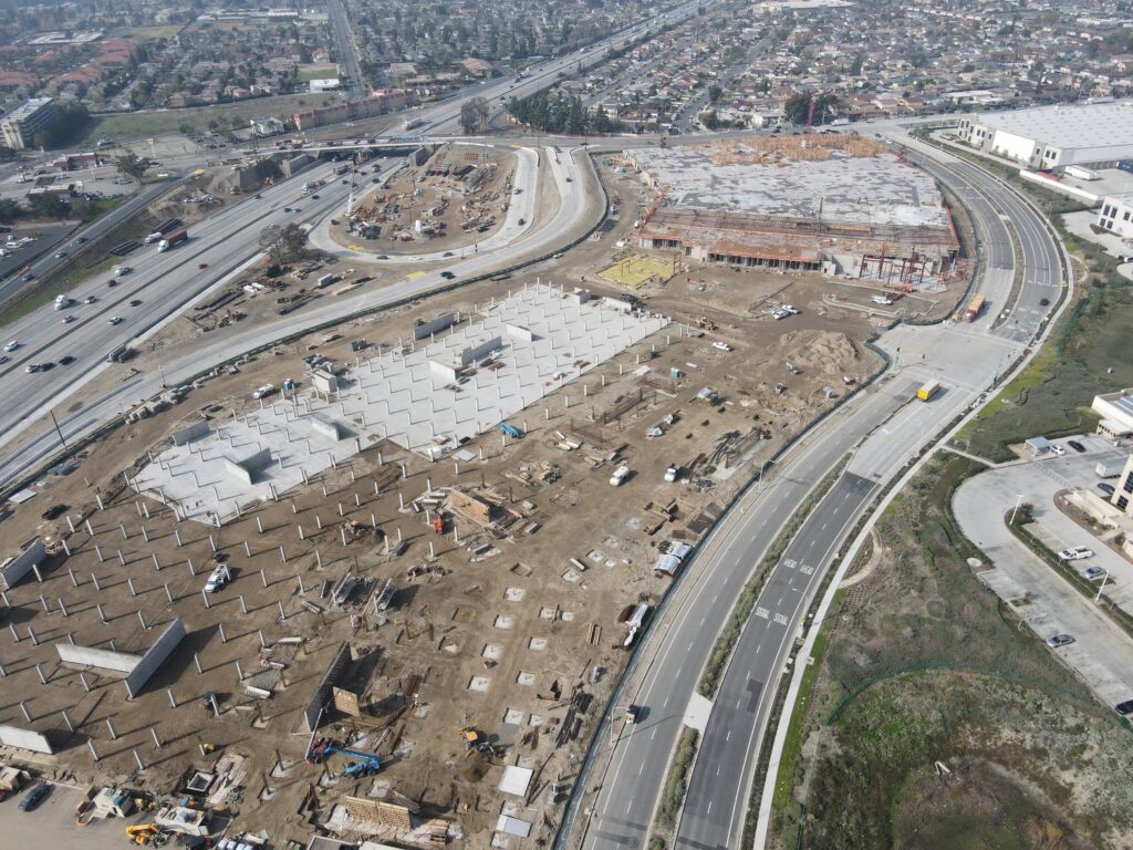 Aerial view of construction site for commercial solar installation on multifamily and retail project.