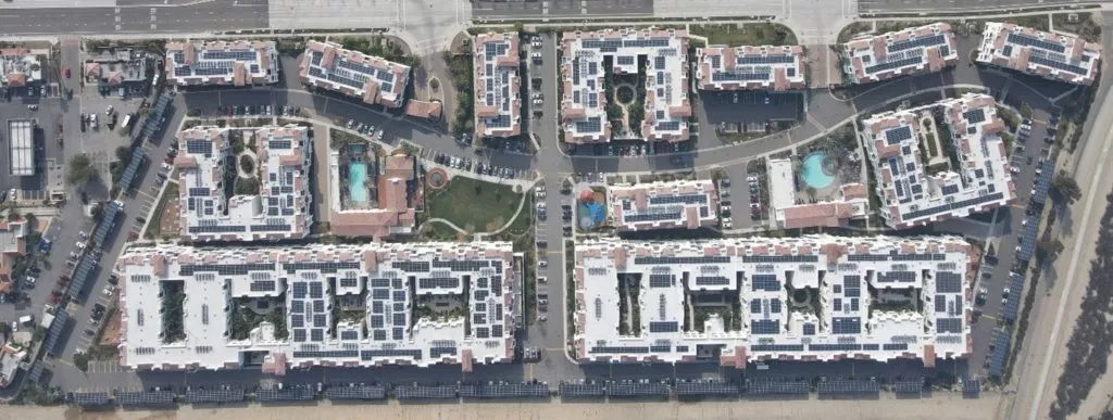 Aerial view of solar carports ring around multifamily project