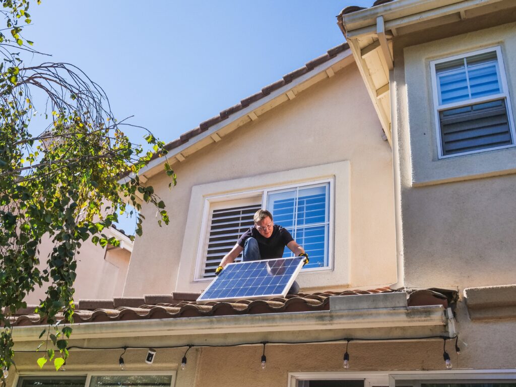 Shot of technician installing solar panel on tile roof in Arizona.