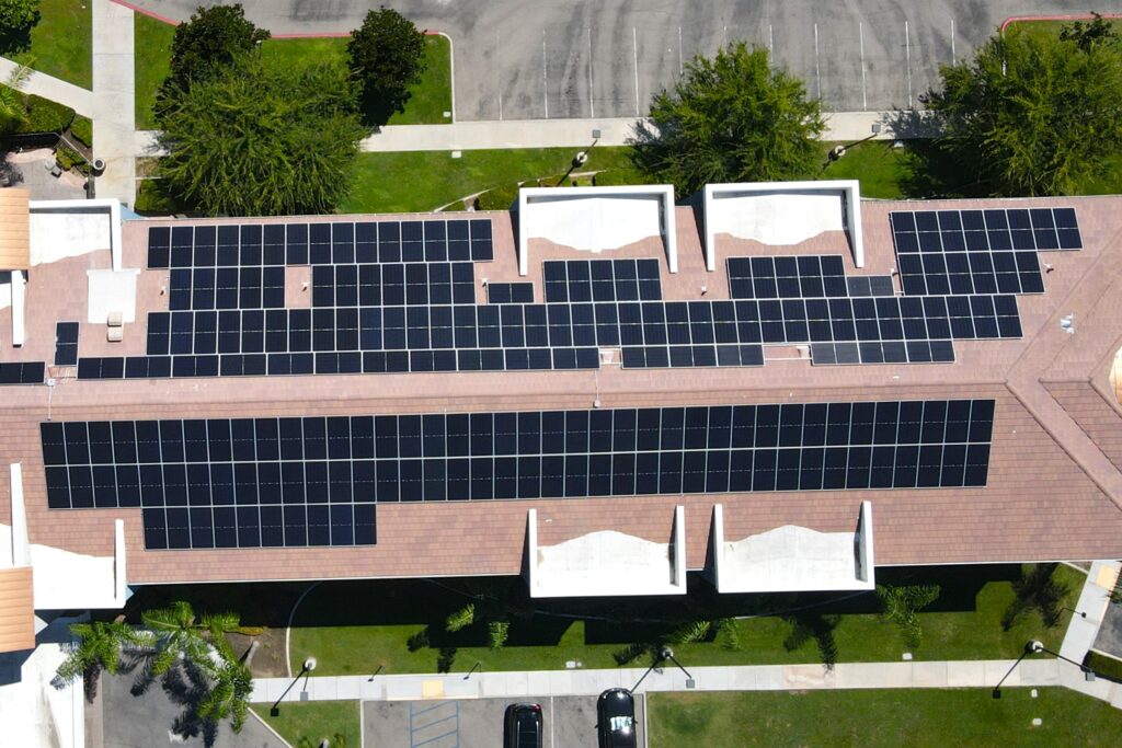 Aerial view of a commercial building in California with solar panels on the roof.